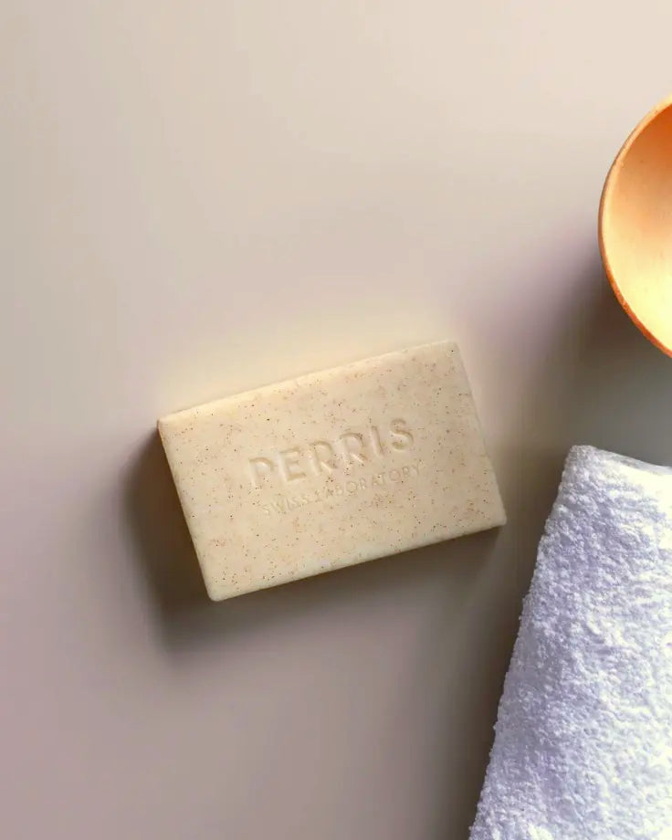 Perris Swiss Laboratory zeep op een zachte handdoek, met een minimalistisch wellnessdecor.