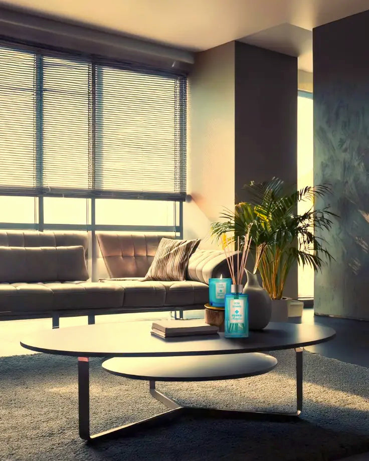 Moderne woonkamer met blauw Perris home fragrance duo op salontafel, omgeven door boeken en een plant