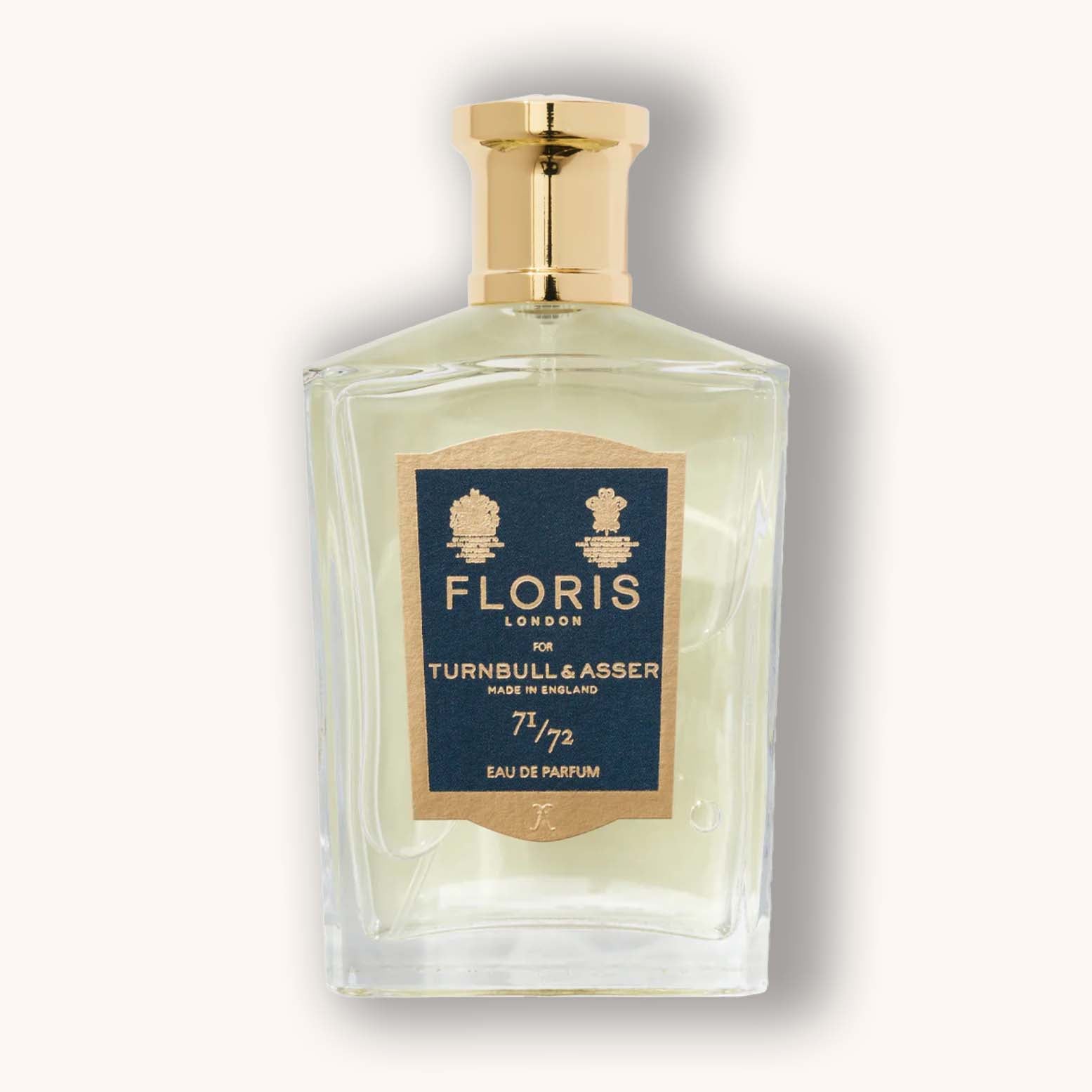 Alt text: A clear glass bottle of Floris London 71/72 Eau de Parfum, featuring a gold cap and a blue label with the brand name and details. The elegant design reflects a classic, sophisticated fragrance.