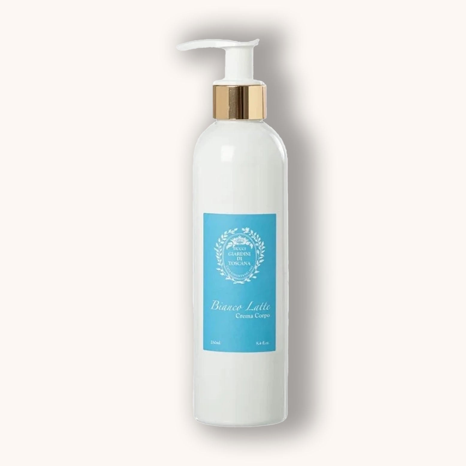 Alt text: A white bottle of Giardini di Toscana Bianco Latte Bodycream, featuring a blue label and a gold pump dispenser, stands elegantly against a light background. The product is designed for moisturizing and nourishing the skin.