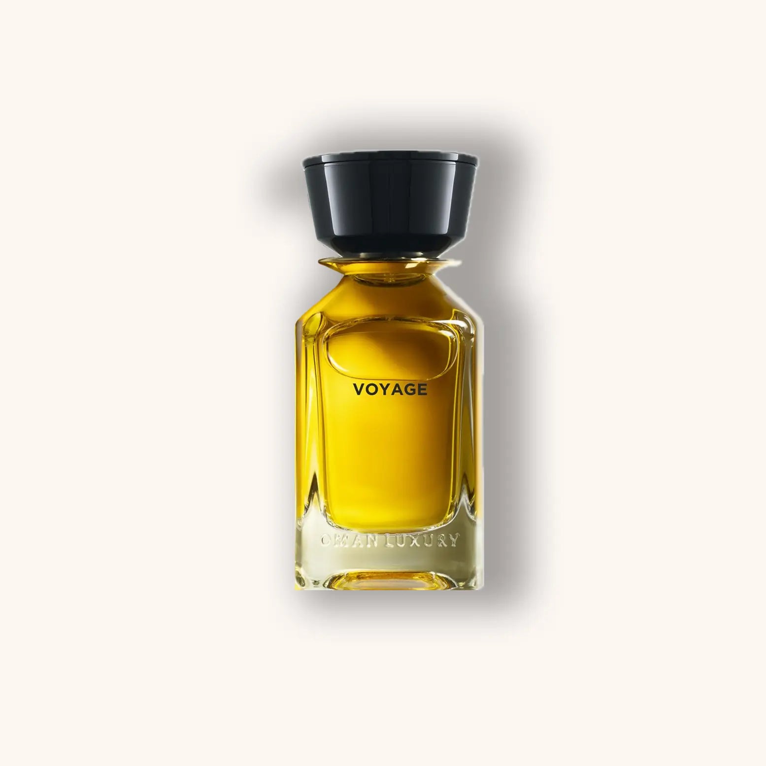Een slanke glazen flacon van de parfum 'Omanluxury Voyage', met een zwarte dop en een goudgele vloeistof, elegant gepresenteerd tegen een lichte achtergrond.