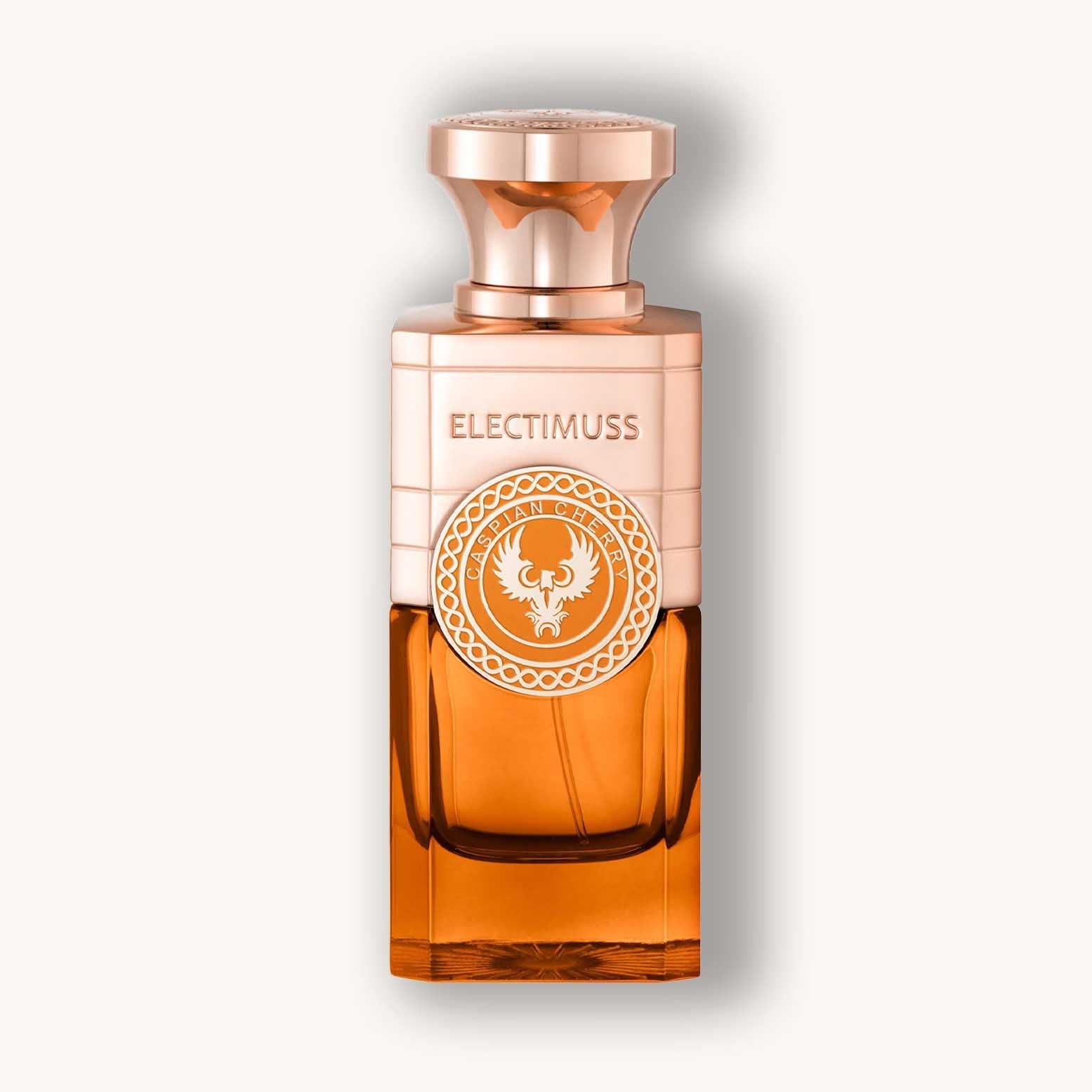 Alt text: A luxurious glass perfume bottle of Electimuss Caspian Cherry, featuring an elegant rose gold cap and a distinctive emblem on the front. The rich amber liquid inside hints at a sophisticated fragrance.