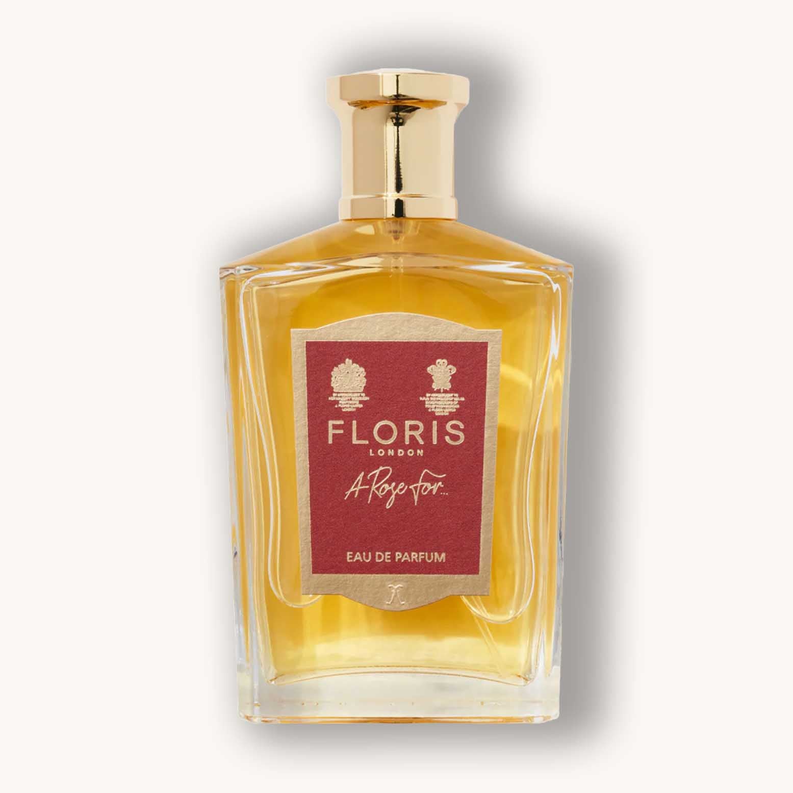 Alt text: A clear glass bottle of Floris London A Rose For..., featuring a gold cap and a red label, containing a golden yellow Eau de Parfum.