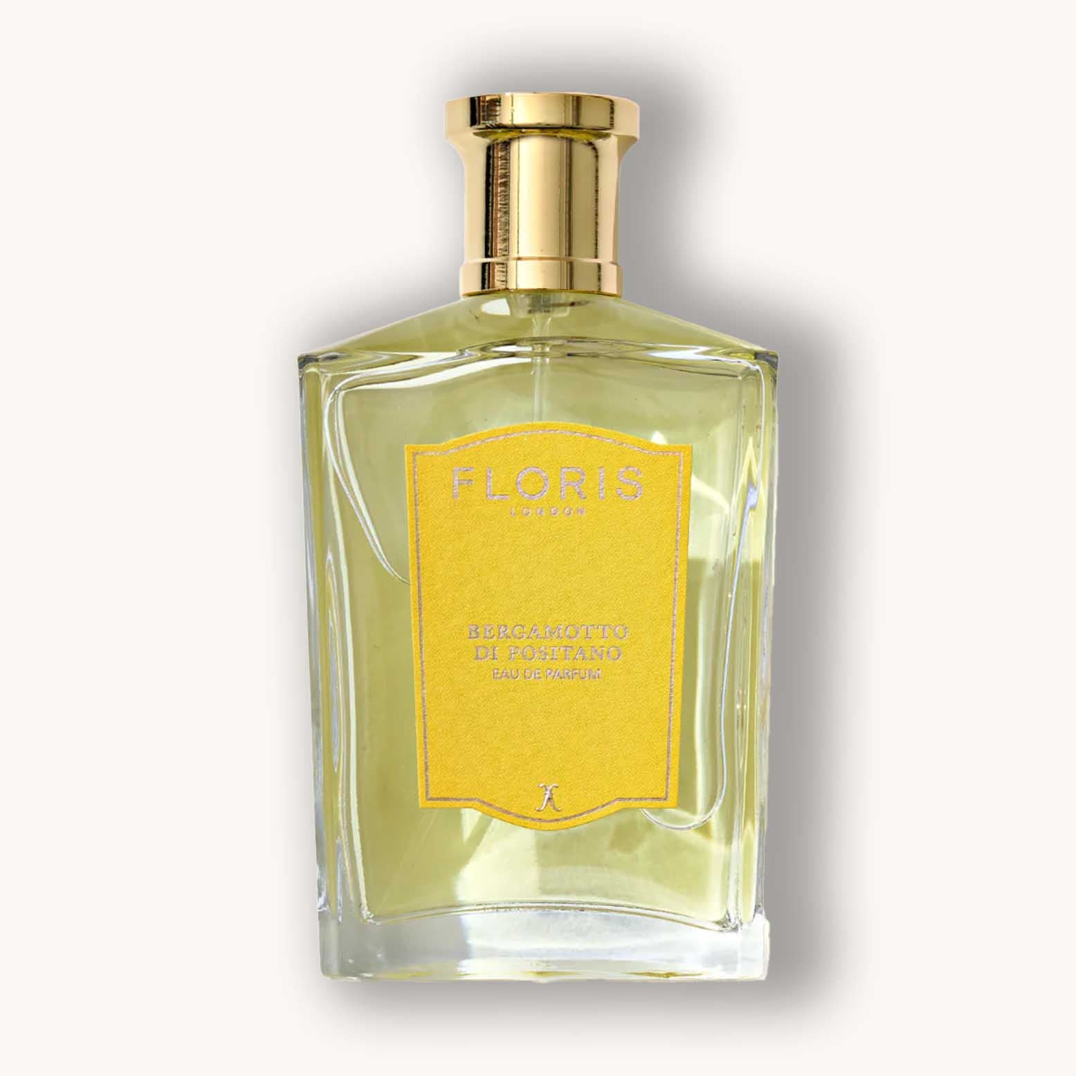 A translucent glass bottle of Floris London Bergamotto di Positano Eau de Parfum, featuring a striking yellow label and gold accents, exuding a fresh and citrusy aroma.