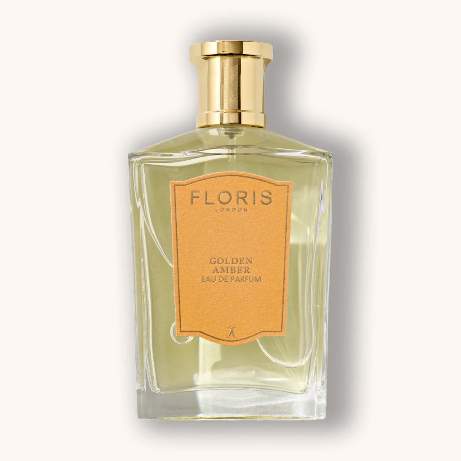 Alt text: A bottle of Floris London Golden Amber Eau de Parfum, featuring a sleek, angular glass design with a gold cap and a warm orange label that reads "Golden Amber."