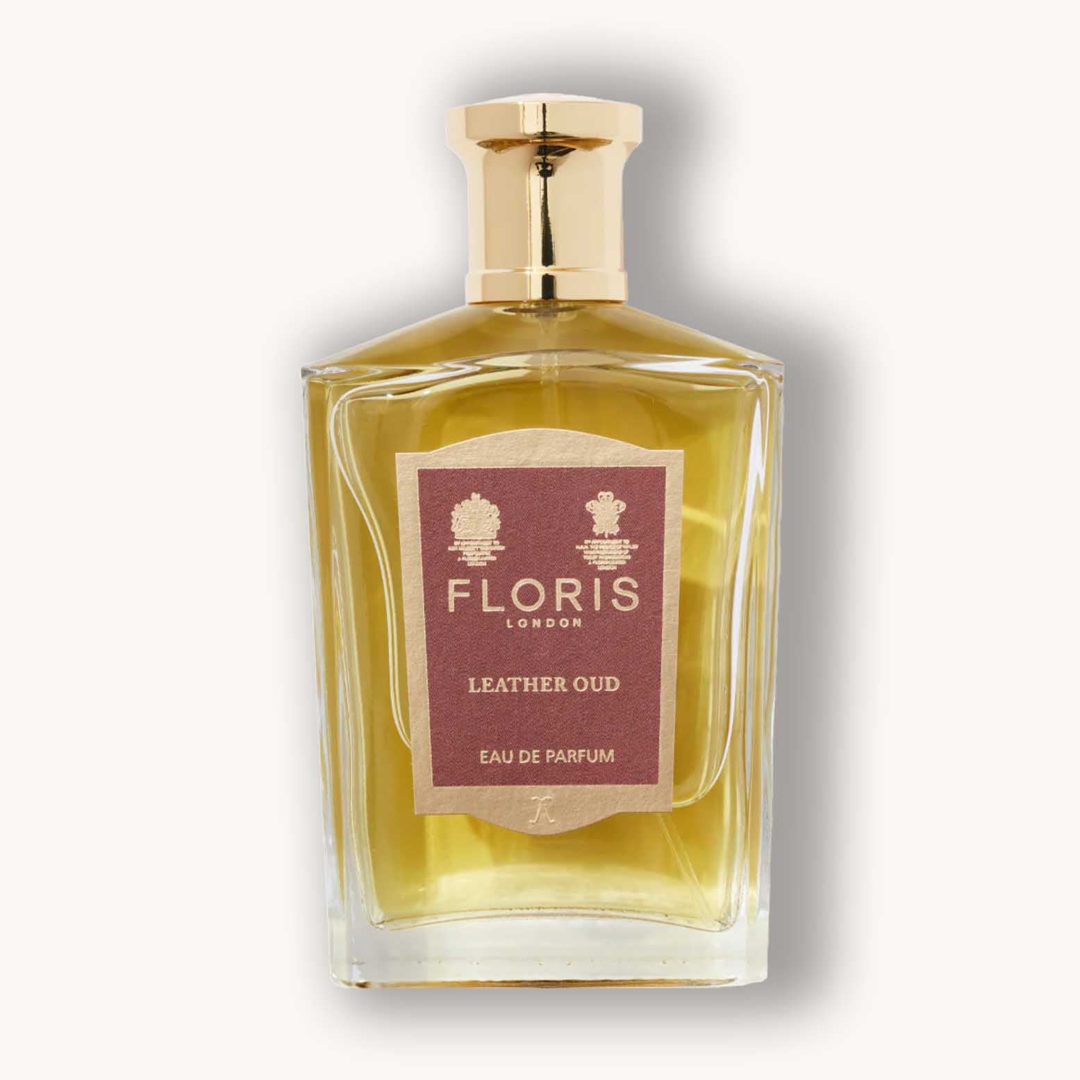 Alt text: A clear glass bottle of Floris London Leather Oud Eau de Parfum, featuring a gold cap and a brown label with elegant text. The fragrance exhibits a warm, luxurious blend, capturing the essence of rich leather and oud.