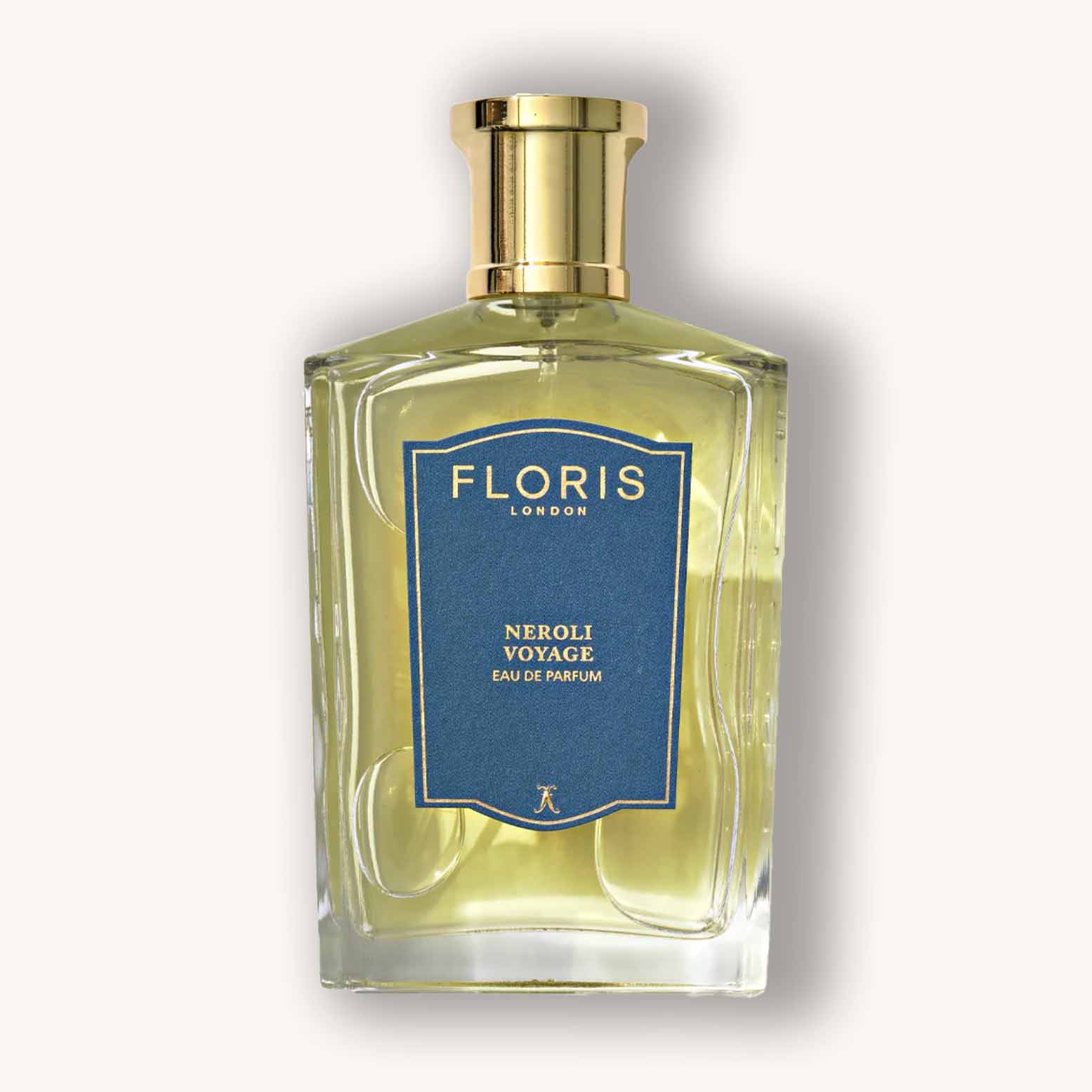 Alt text: A clear glass bottle of Floris London Neroli Voyage eau de parfum, featuring a gold cap and a blue label detailing the fragrance name. The liquid inside is a light yellow color, evoking a fresh and uplifting scent.