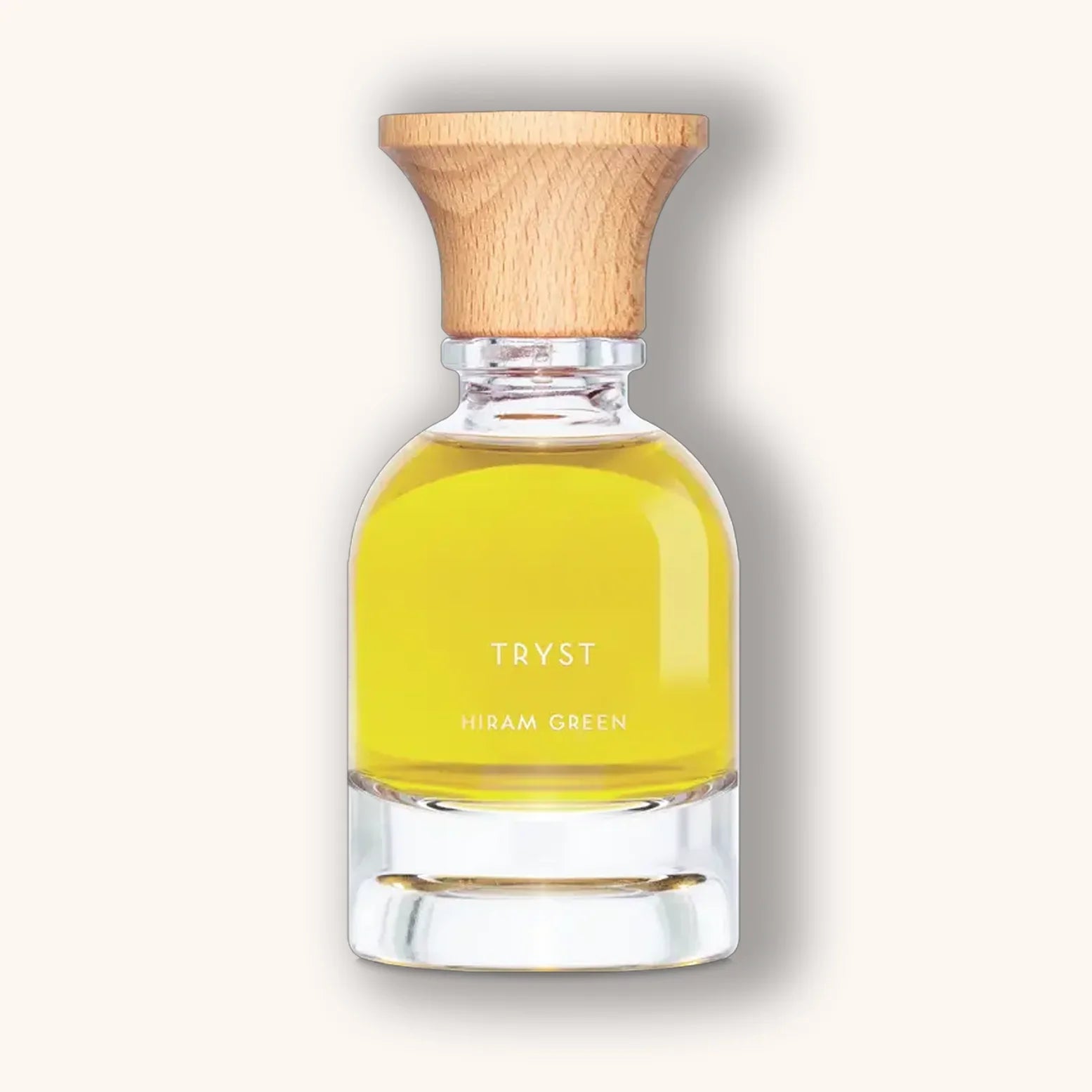 Hiram Green Tryst natuurlijke parfum in een heldere flacon met felgele vloeistof en houten dop.