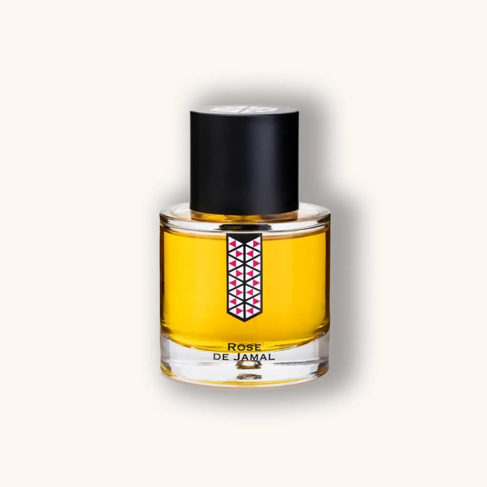Ronde flacon van Les Indémodables Rose de Jamal met licht goudgele inhoud, zwarte dop en geometrisch roze-zwart label.