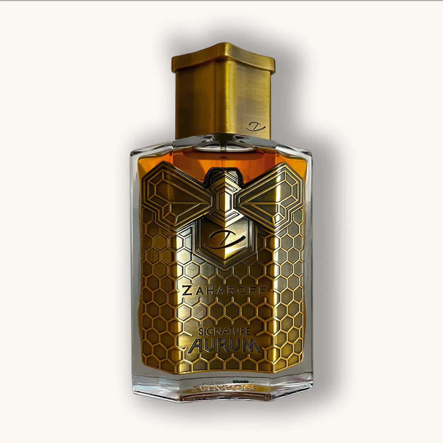 Zaharoff Signature Aurum parfumfles met gouden honingraatmotief en bijenillustratie, goudkleurige dop en warme amberkleurige inhoud, exclusieve luxe geur.