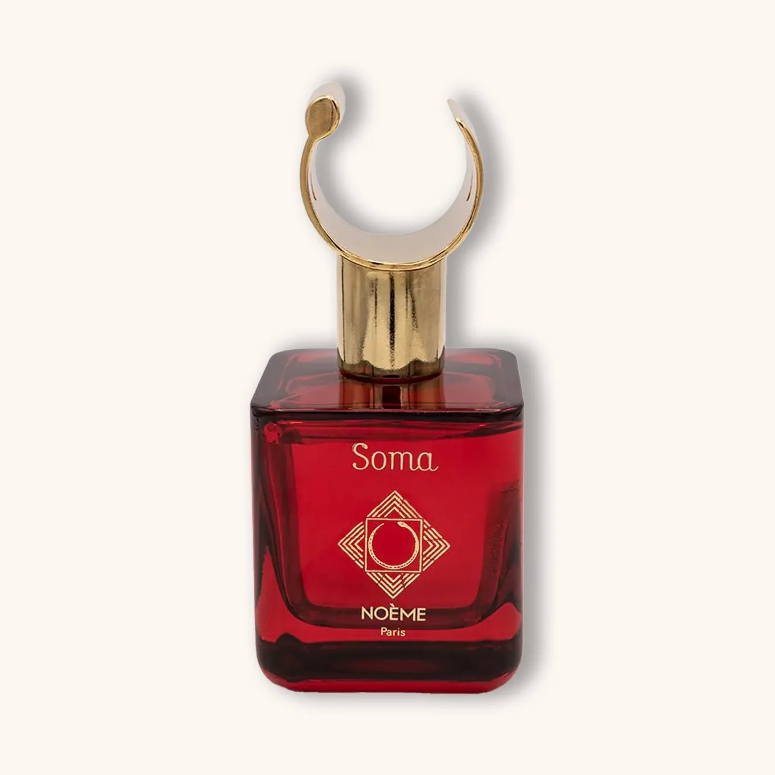 Alt text: A stylish red perfume bottle labeled "Noème Paris Soma," featuring a unique, gold crescent-shaped cap that adds an elegant touch to its design.
