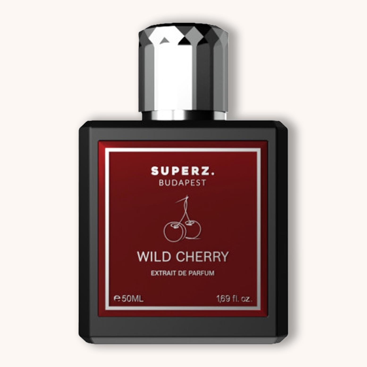 A sleek black bottle of Superz Wild Cherry perfume, featuring a bold red label with the text "WILD CHERRY" and a cherry graphic. The bottle contains 50 mL of extrait de parfum.